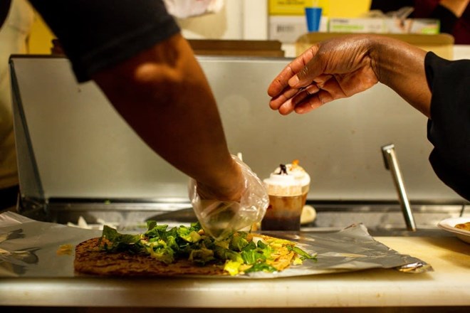 Karima Omer, owner of Sabrina's Cafe & Deli in St. Paul, finishes a Chapati and beef wrap.Nicole Neri for MPR News